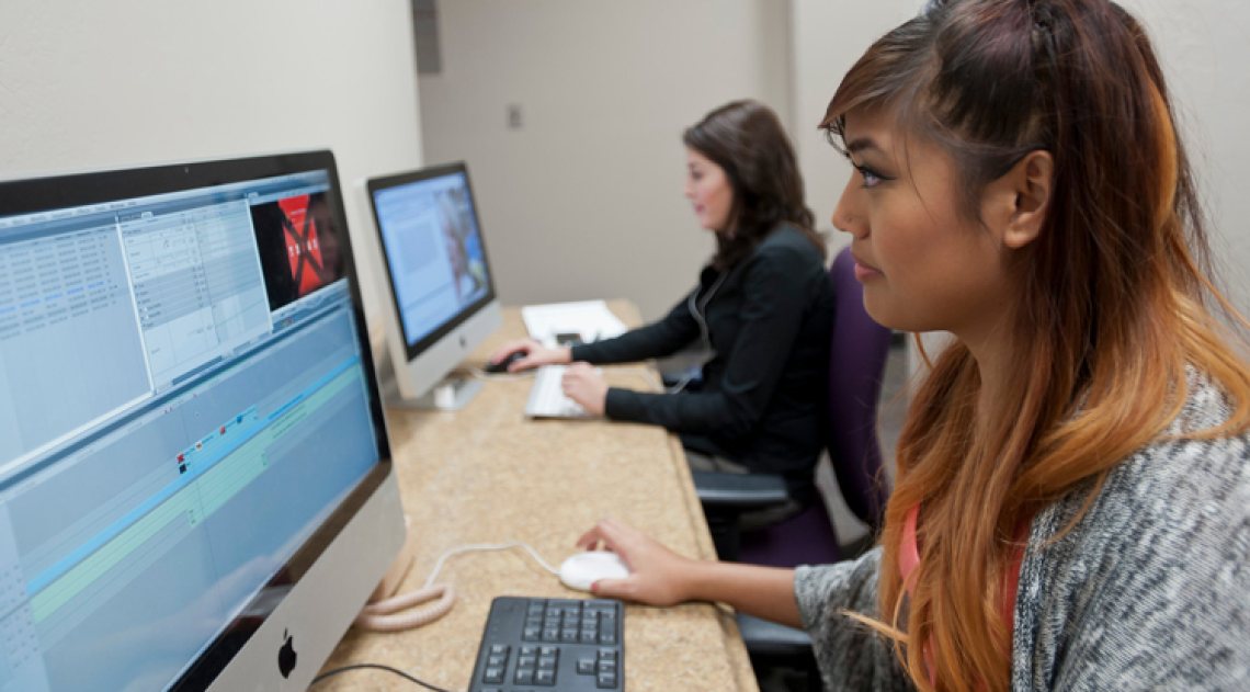 Female student editing video footage on a computer