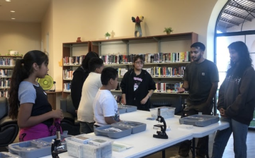 students in a library working together using microscopes
